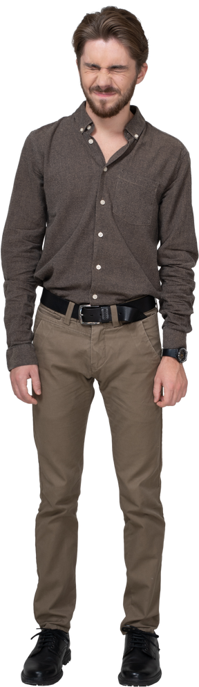 Front view of a grimacing displeased young man in office clothing