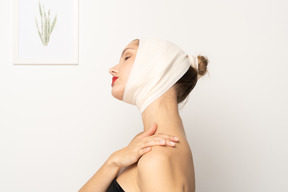 Woman with head bandage touching her shoulder