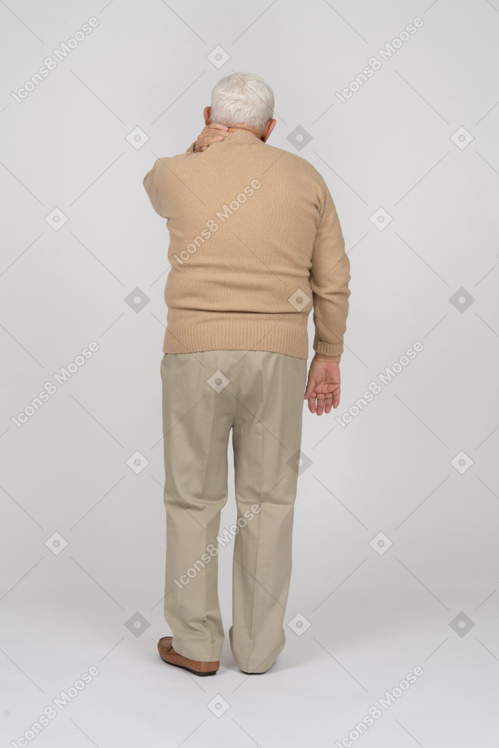 Rea view of an old man in casual clothes suffering from pain in neck