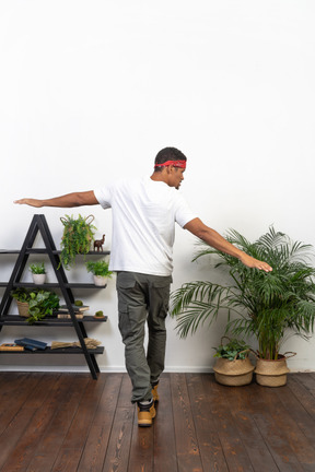 Good looking young man posing on the background of the apartment