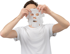 Front view of a young man ready to put on facial mask