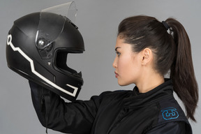 Uma mulher jovem e bonita olhando um capacete