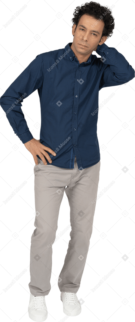 Vista frontal de um homem com roupas casuais, posando com a mão atrás da cabeça