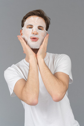 Front view of a young man posing in facial mask