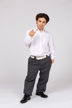 Man in formal wear showing rock hand gesture