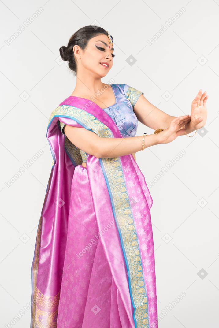紫色莎丽的年轻印地安妇女看她的手的