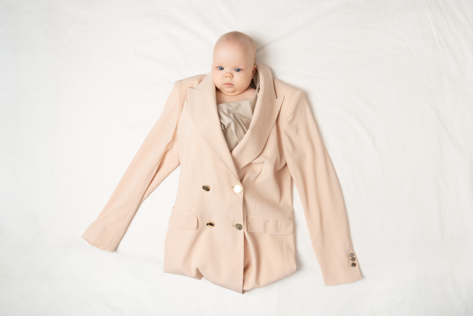 Baby girl in adult's jacket and blouse