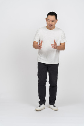 Vista frontal de um homem em roupas casuais, mostrando o tamanho de algo