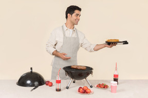 Joven hombre caucásico preparando barbacoa