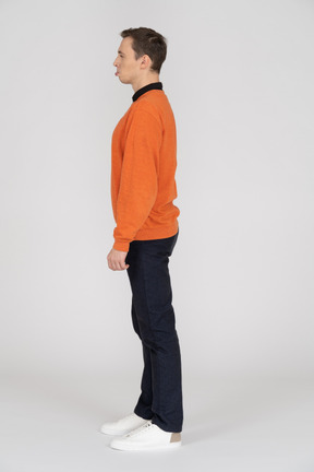 Joven en sudadera naranja de pie