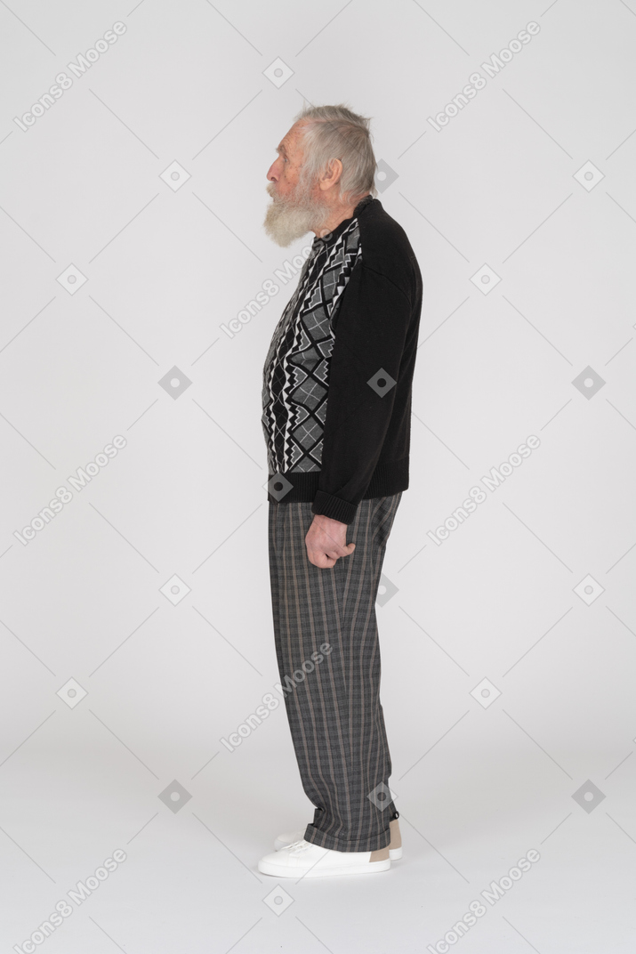 Side view of an old man standing looking shocked