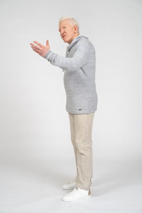Вид в три четверти на человека, стоящего и поднимающего левую руку