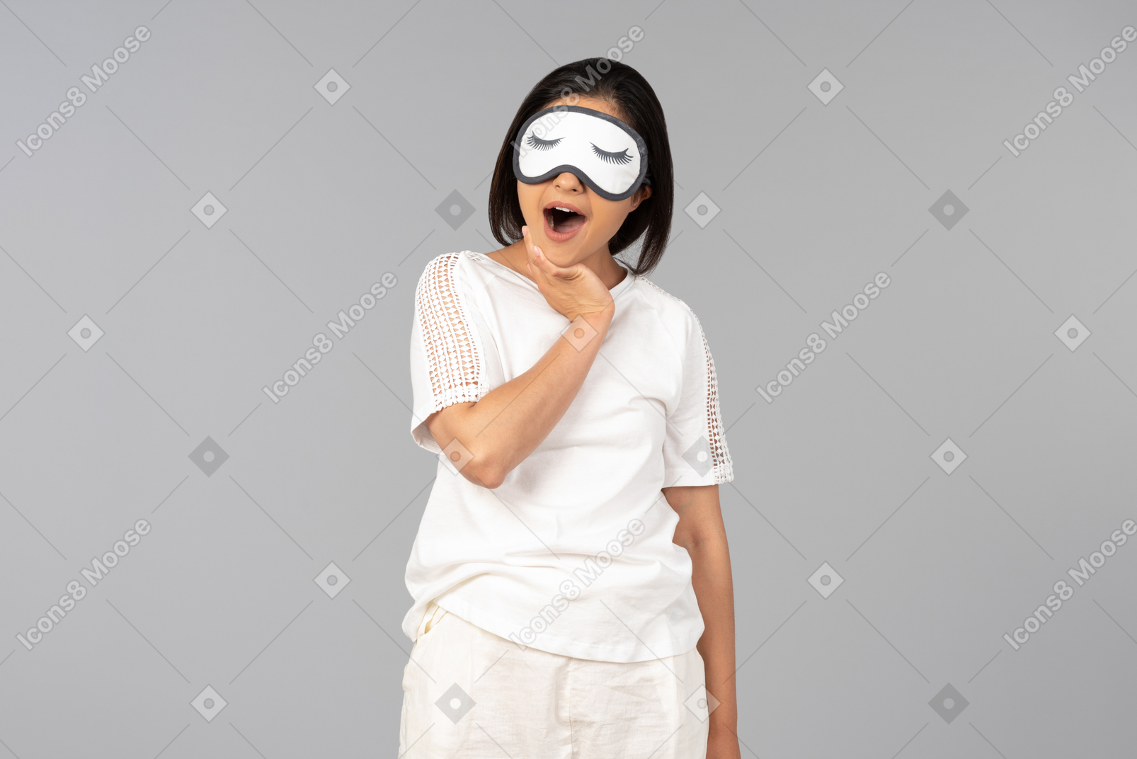 Young indian woman in comfy clothes in sleeping mask yawning
