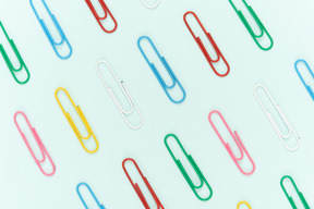 Colourful paper clips on blue background