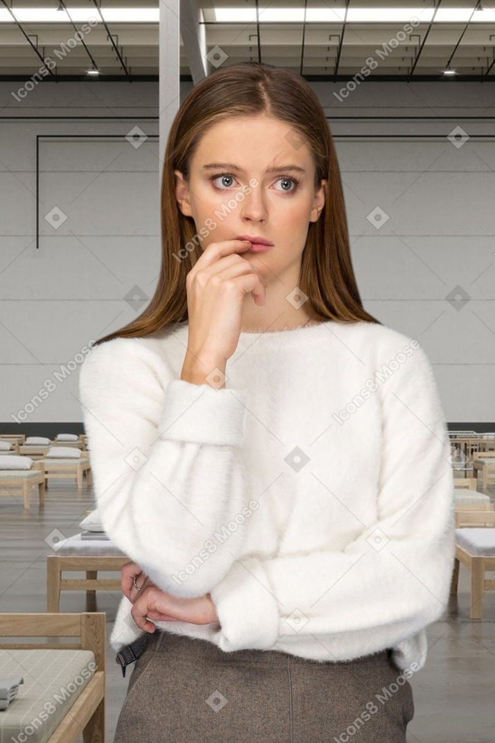 A nervous looking woman standing on a hospital background