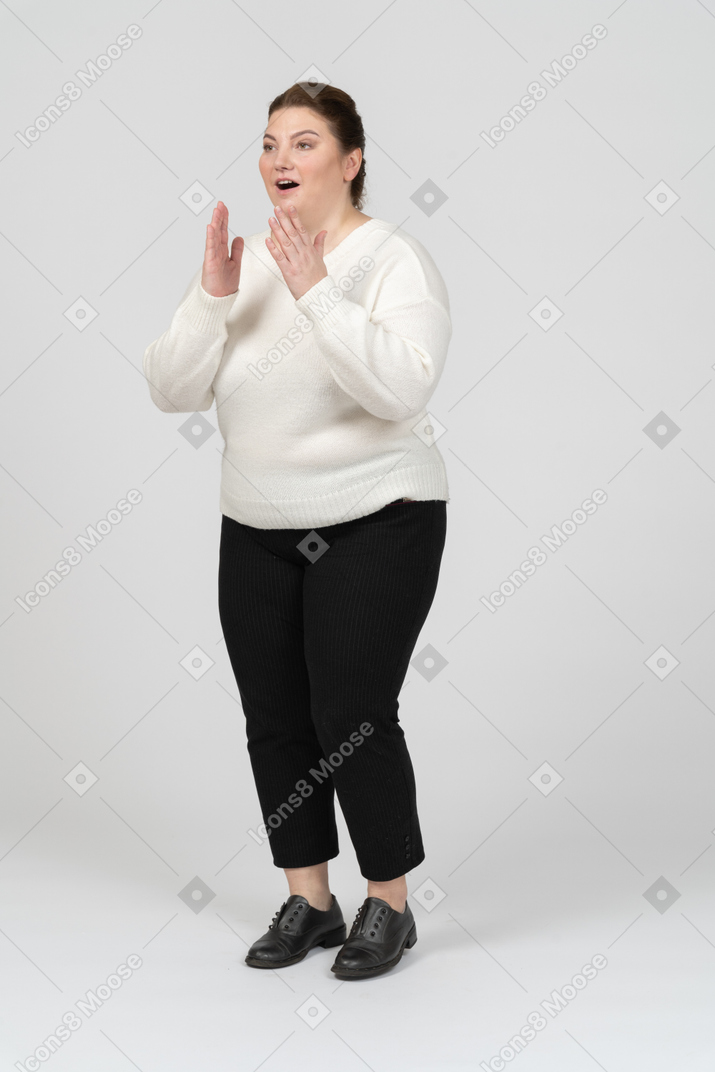 Donna grassoccia sorpresa in abiti casual in piedi di profilo