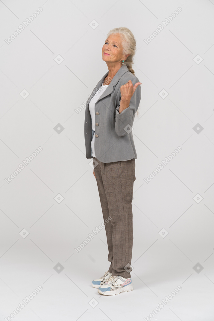 身振りで示すスーツで幸せな老婦人の側面図
