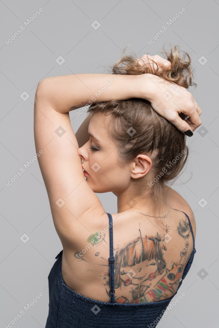 Giovane donna che alza i capelli