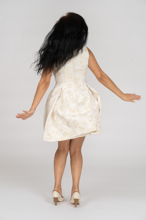 Женщина в белом платье танцует