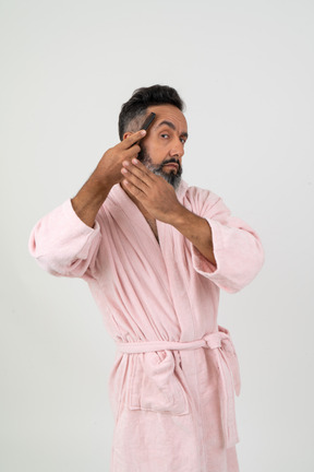 Mature guy styling his hair with a comb