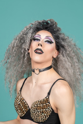 Drag queen de sutiã cravejado com cabeça inclinada para trás