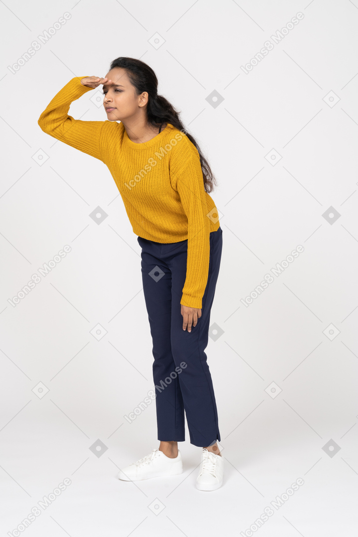 Vista lateral de uma garota com roupas casuais procurando por alguém