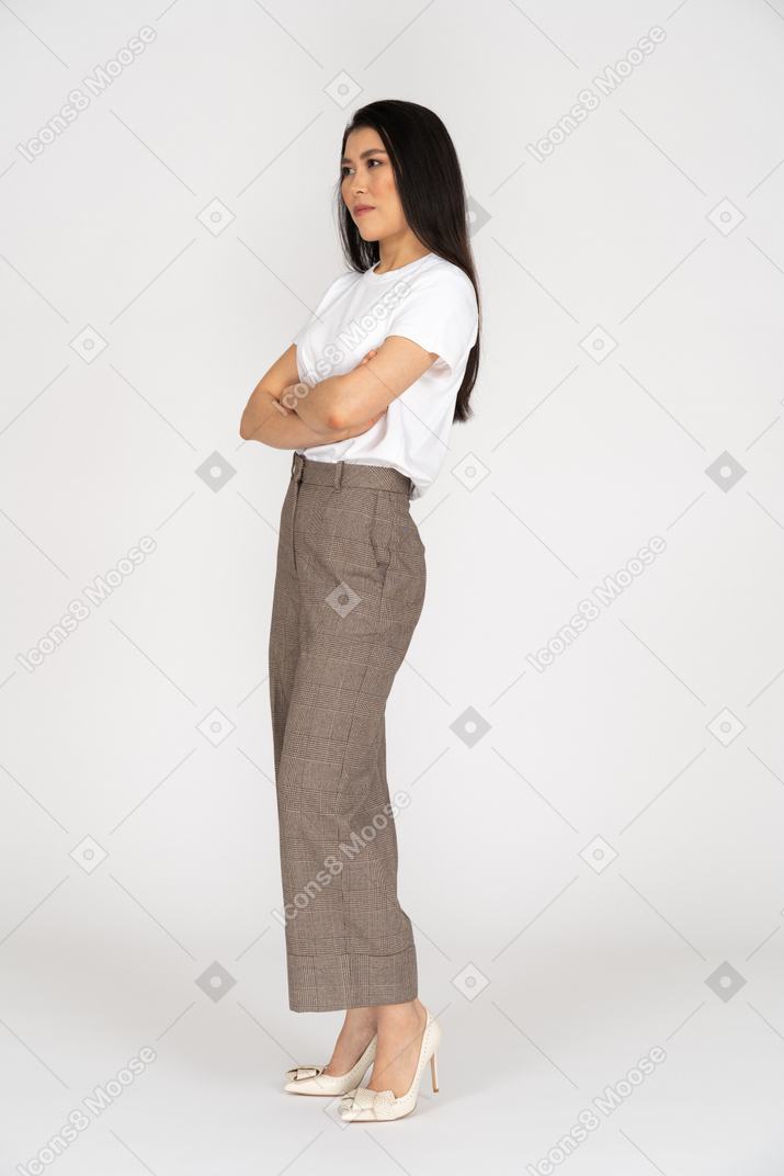 Three-quarter view of a young woman in breeches crossing hand