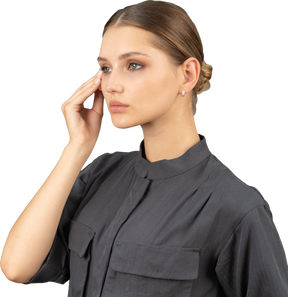 Three-quarter view of a young woman in a jumpsuit removing eye make-up