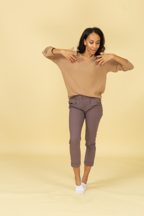 Front view of a dark-skinned young female raising hands