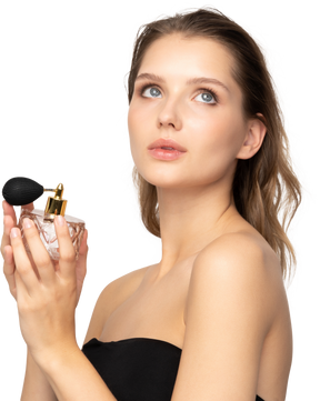 Side view of a young woman applying face powder while holding a mirror