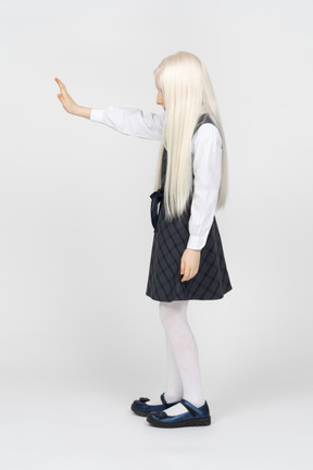Side view of a schoolgirl with one hand up