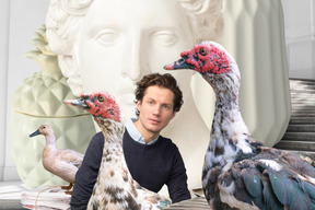 A man standing next to unusual birds