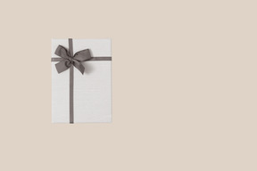 A white gift box with a gray bow