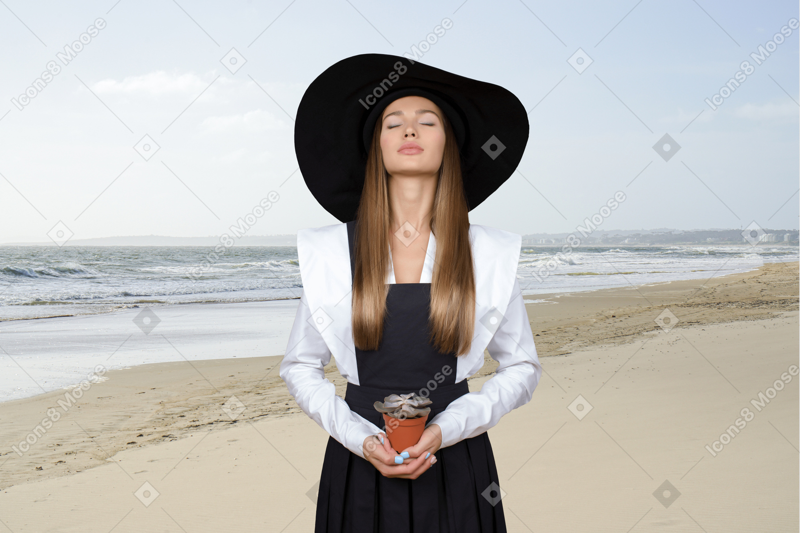 Woman with long hair wearing a black hat on the beach