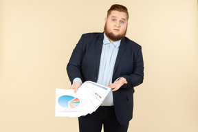 Trabalhador de escritório masculino com excesso de peso, mostrando papéis