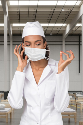 Female doctor in face mask standing in a makeshift hospital