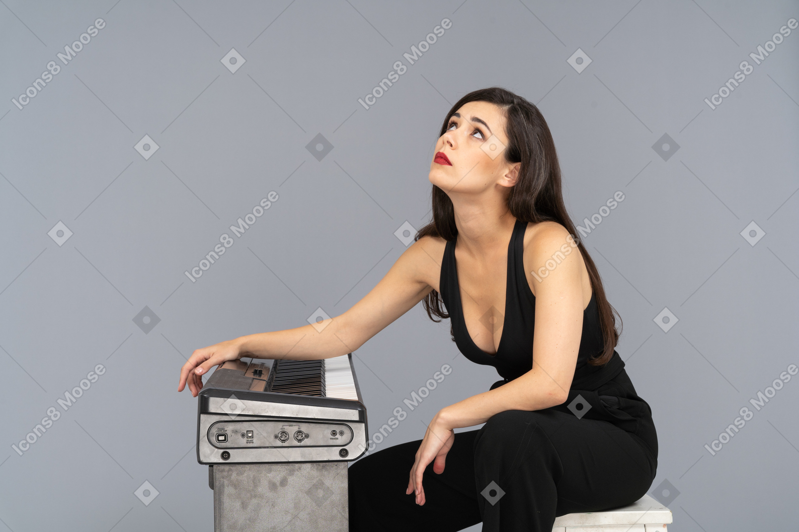 Side view of a bored young female sitting by the piano