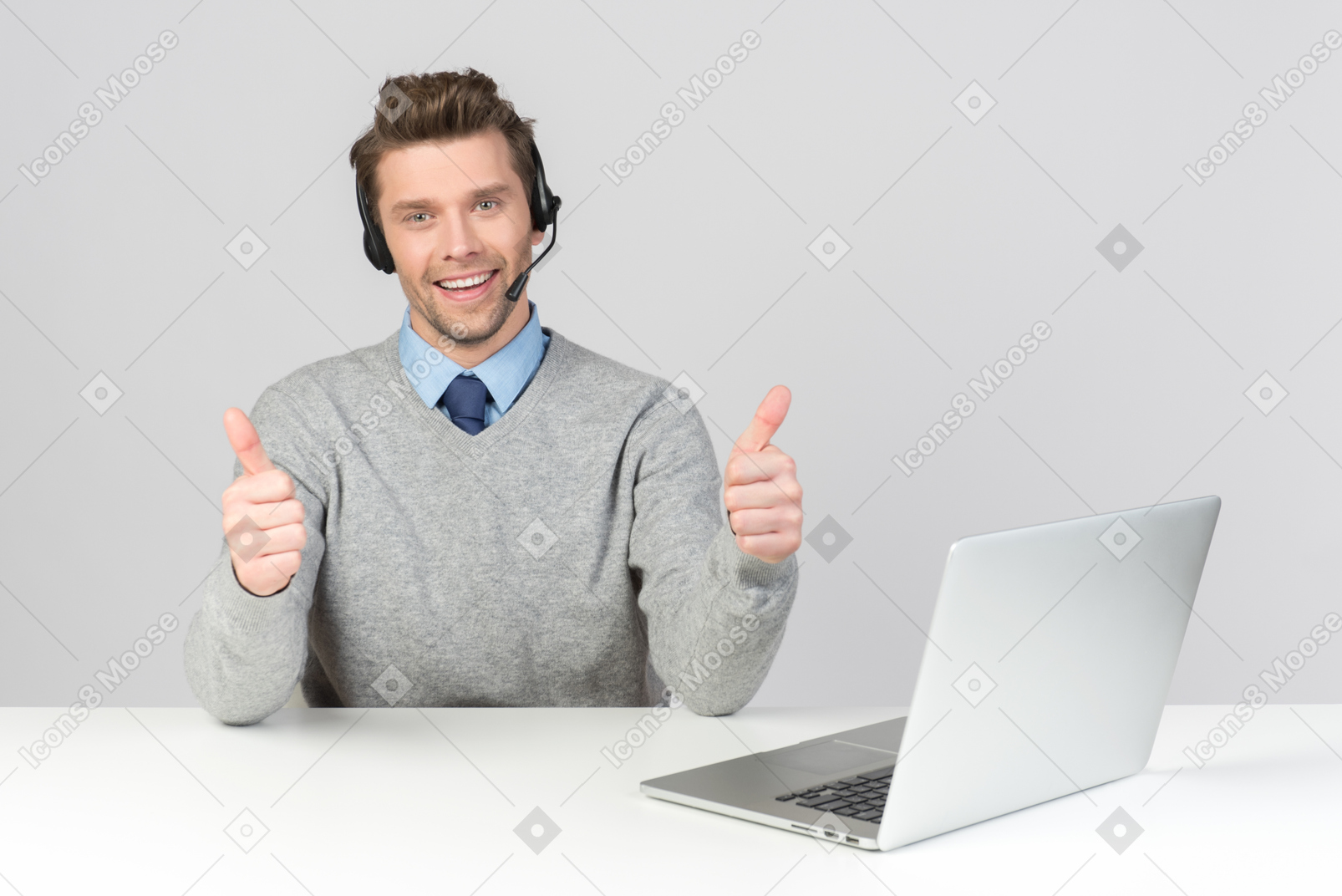 Call center agent sitting at work place and showing thumbs up