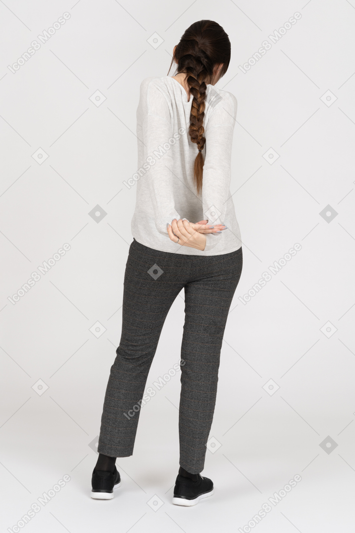 Unrecognizable brunette female stretching arms behind the back