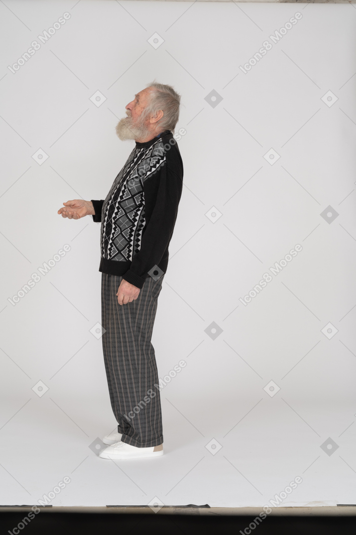 Side view of old man putting out hand