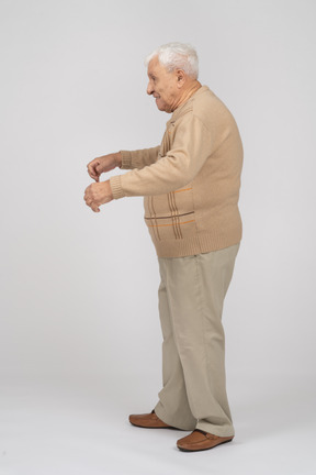 Side view of an old man in casual clothes walking