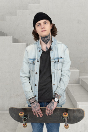 A young man holding a skateboard in his hands