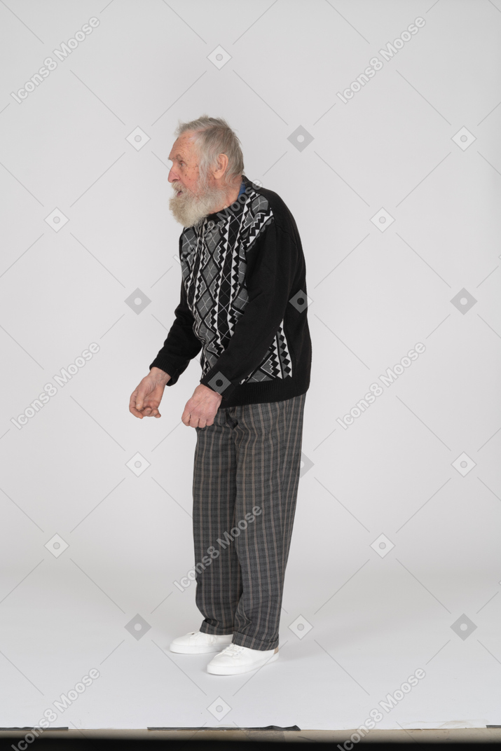 Side view of old man bending down and staring