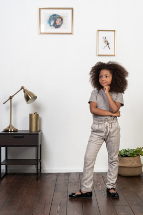 Good looking girl kid posing on the apartment background