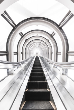 Una imagen en blanco y negro brillante de una escalera mecánica en movimiento