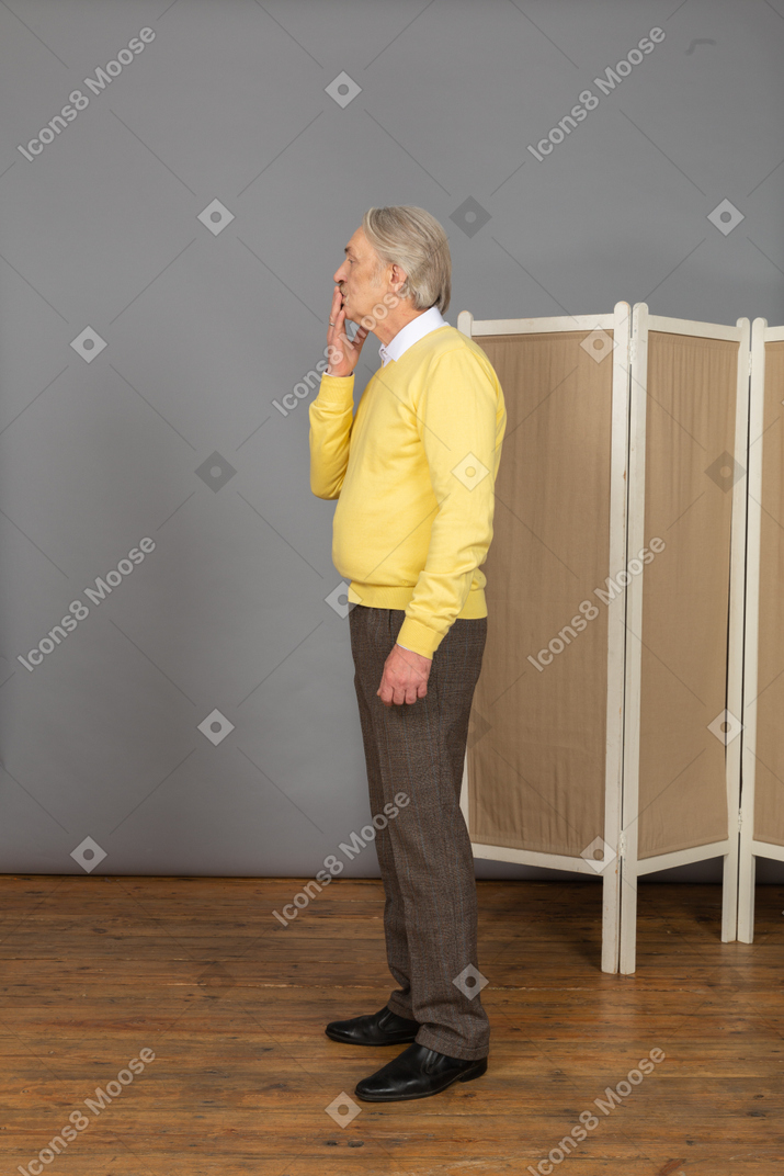 Side view of an old man sending an air kiss