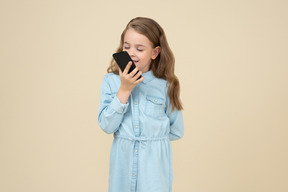 可爱的小女孩抱着一部智能手机