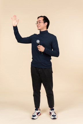 Young asian man speaking into a microphone