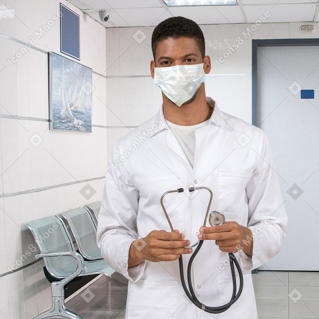 A man in a white lab coat holding a stethoscope