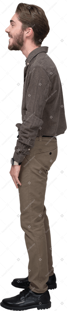 Vista lateral de un joven riendo en ropa de oficina
